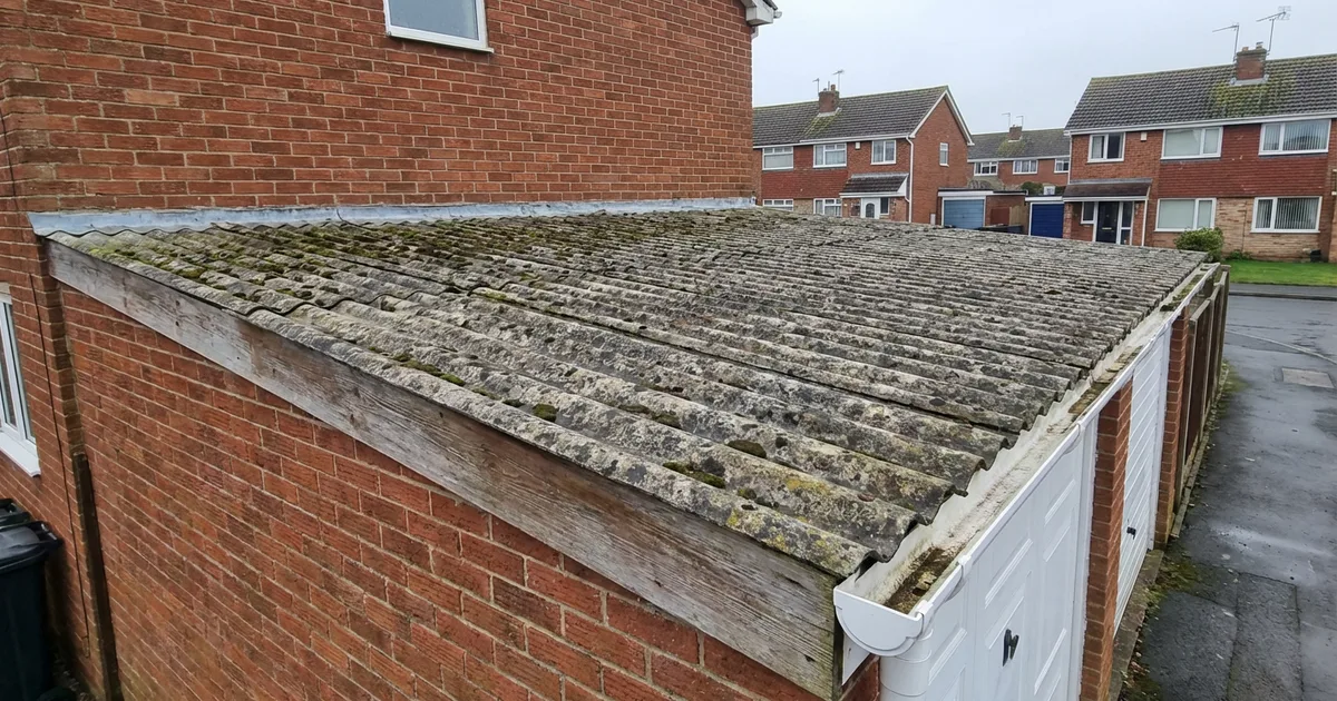 Weathered corrugated asbestos cement roof on a UK domestic garage